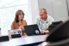 A student shows her game to a faculty member